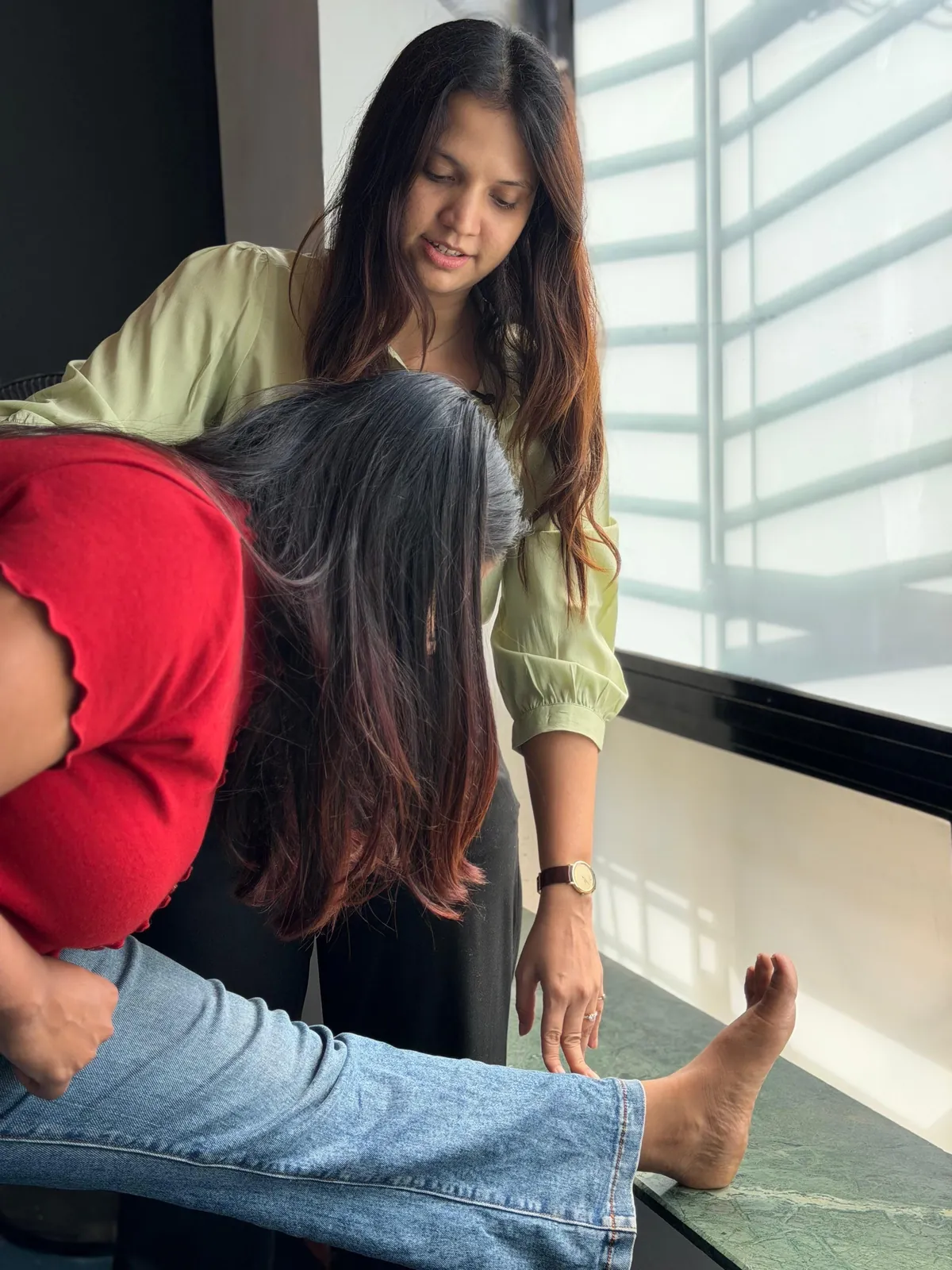 Physiotherapist guiding a patient through a supported leg stretch