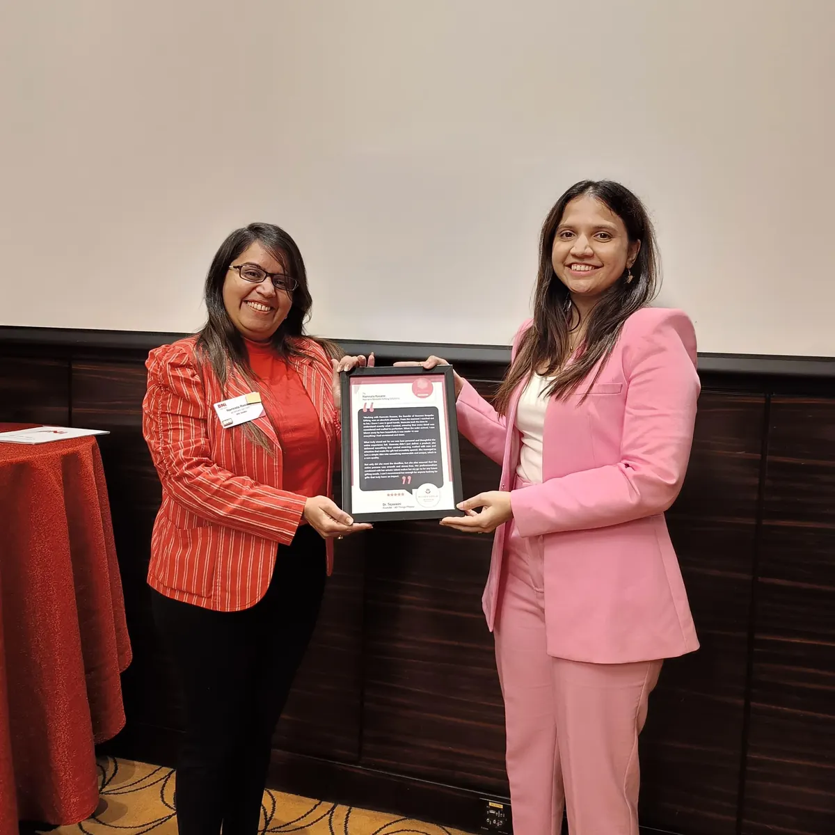 Dr. Tejaswini receiving a certificate of recognition